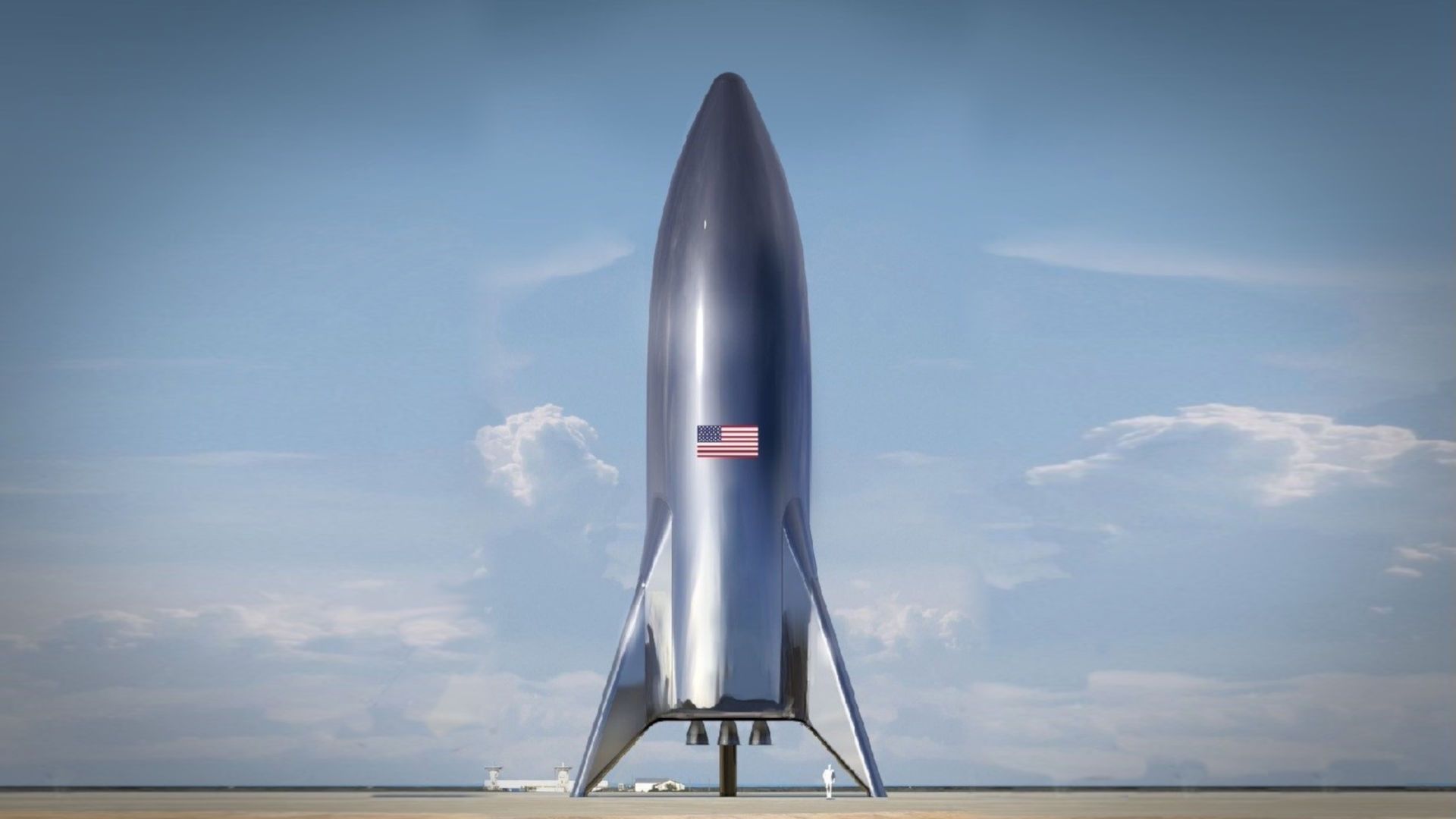5. La última frontera. A large, sleek rocket stands on a launch pad under a clear blue sky with scattered clouds. The rocket is adorned with a United States flag. Opens a video in a new window.