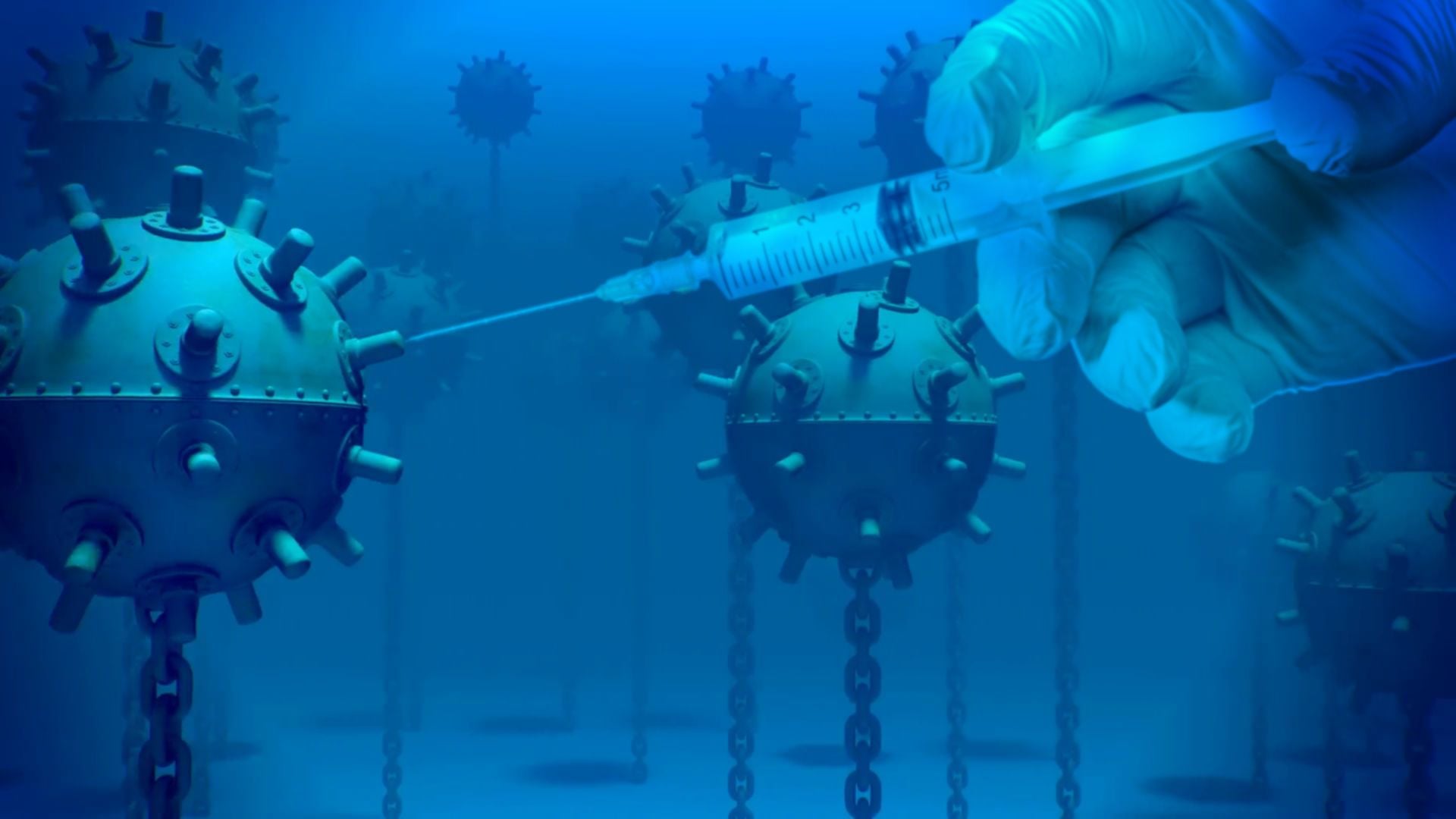 6. Luchando por la paz. A surreal illustration showing a gloved hand holding a syringe, injecting a fluid into a spherical structure adorned with protrusions, resembling a virus. Several similar structures are suspended in the background, all set against a deep blue backdrop. Opens a video in a new window.