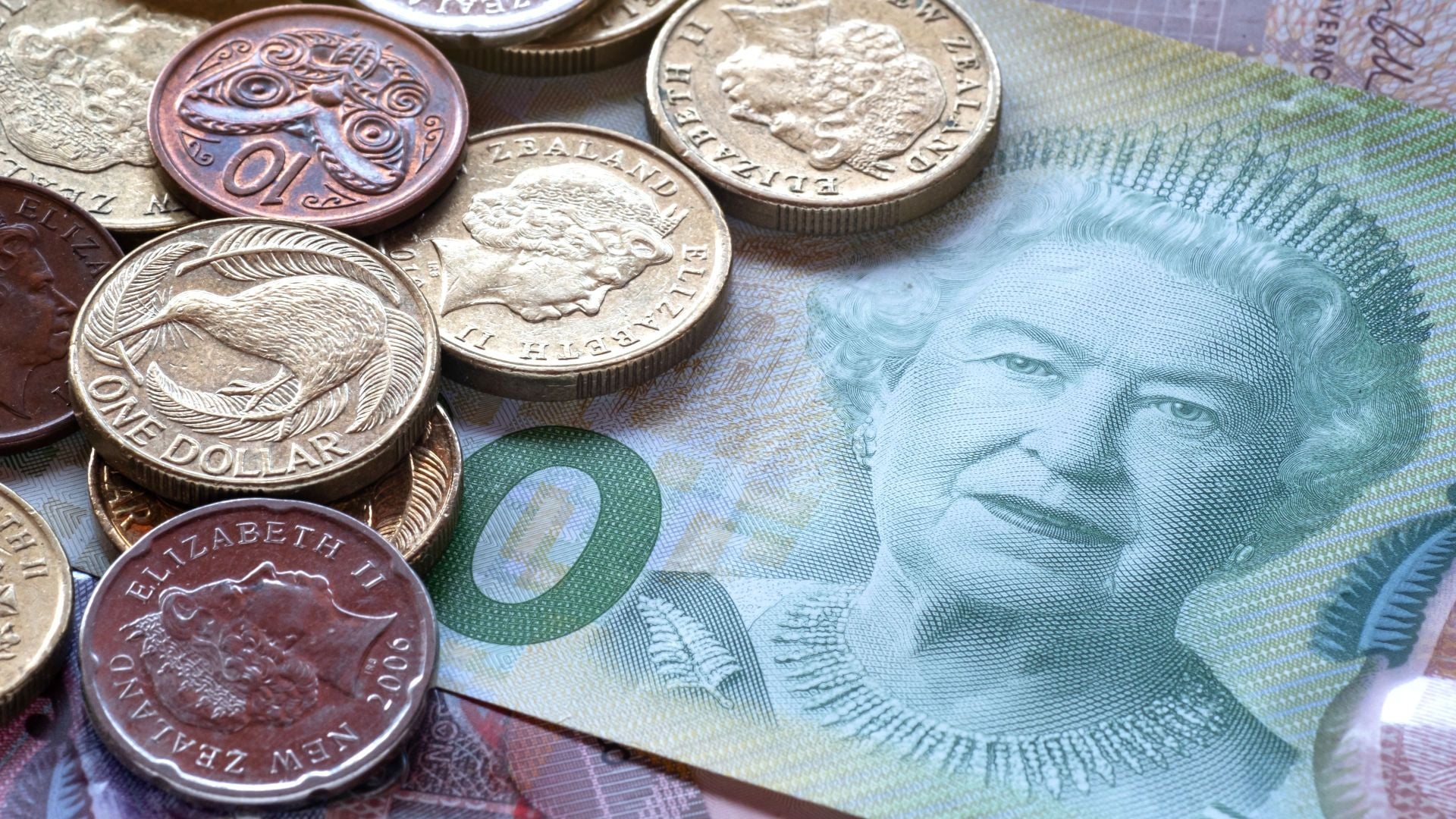 2. Yo estoy sentada como reina. A collection of Australian currency featuring coins and a banknote with an image of Queen Elizabeth II. Coins display various animals including a kangaroo and other symbols. Opens a video in a new window.