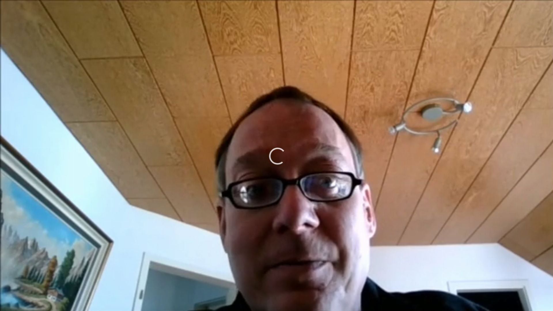 16. Allein durch den Herrn. A man appears on a video call with an intrigued expression. Behind him, a rustic wooden ceiling and a traditional landscape painting enhance the warm ambiance of the room. Opens a video in a new window.