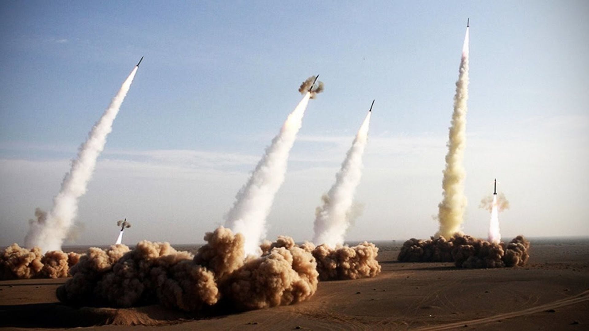 8. Ballistic Missile Launch Compilation. Multiple rockets launching simultaneously from a desert base, creating thick trails of smoke and dust against a clear sky. Opens a video in a new window.