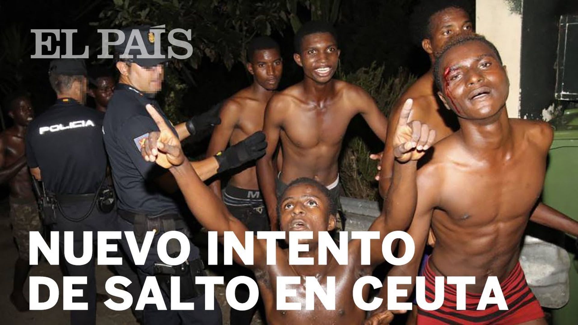 9. Nuevo asalto masivo al paso fronterizo de Ceuta. A nighttime scene showing a group of young men, some with visible injuries, surrounded by law enforcement officers. The text "Nuevo intento de salto en Ceuta" appears at the top of the image. Opens a video in a new window.