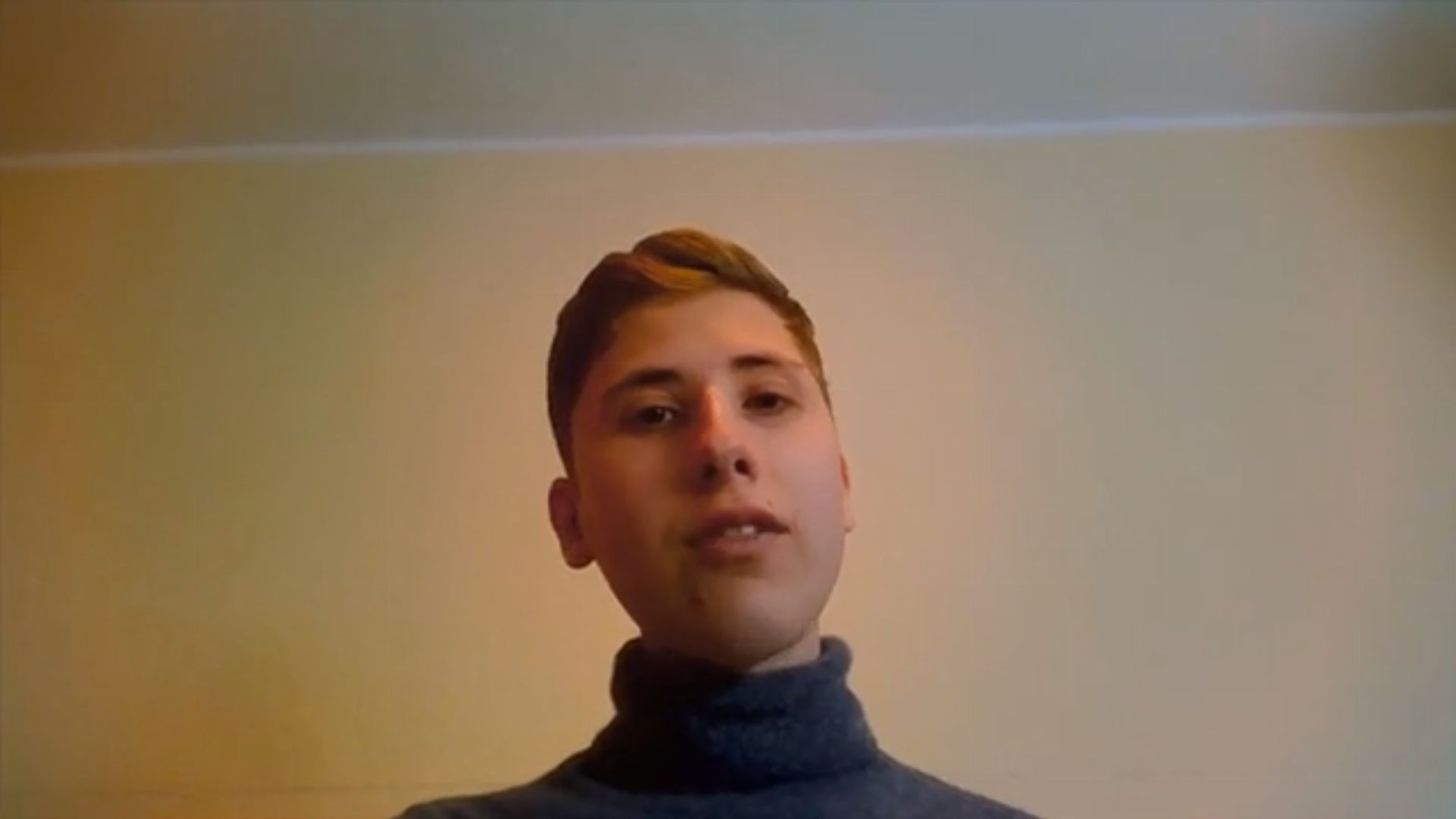 9. Der vierte Engel und das Zeichen des Menschensohnes. A young man with short, blonde hair wearing a dark turtleneck sweater, speaking against a plain, lightly colored wall background. Opens a video in a new window.